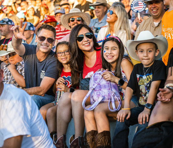family of 5 attending the Folsom Pro Rodeo and smiling at the camera