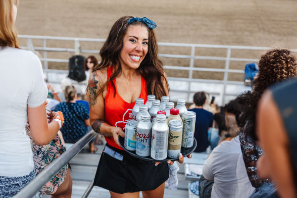 corral club girl serving drinks and smiling at the camera